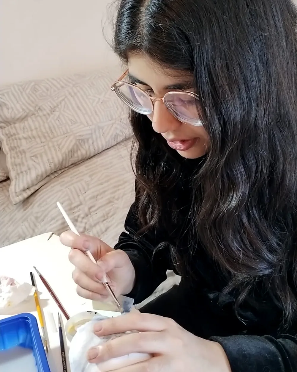 Pintando a pincel una pieza en el taller