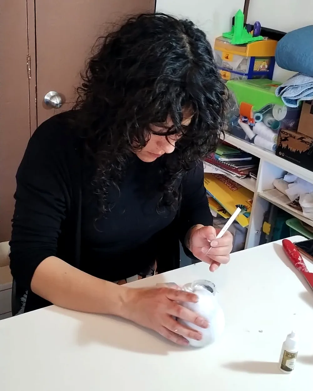 Pintando detalles a pincel en el taller familiar
